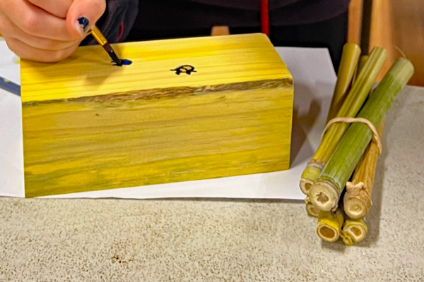 A workshop bee hotel being painted.