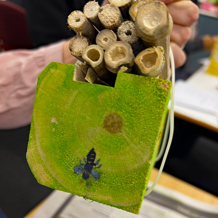 A completed bee hotel made during a workshop, with bamboo tubes attached to provide an alternative type of nesting cavity to the holes drilled in the wood.
